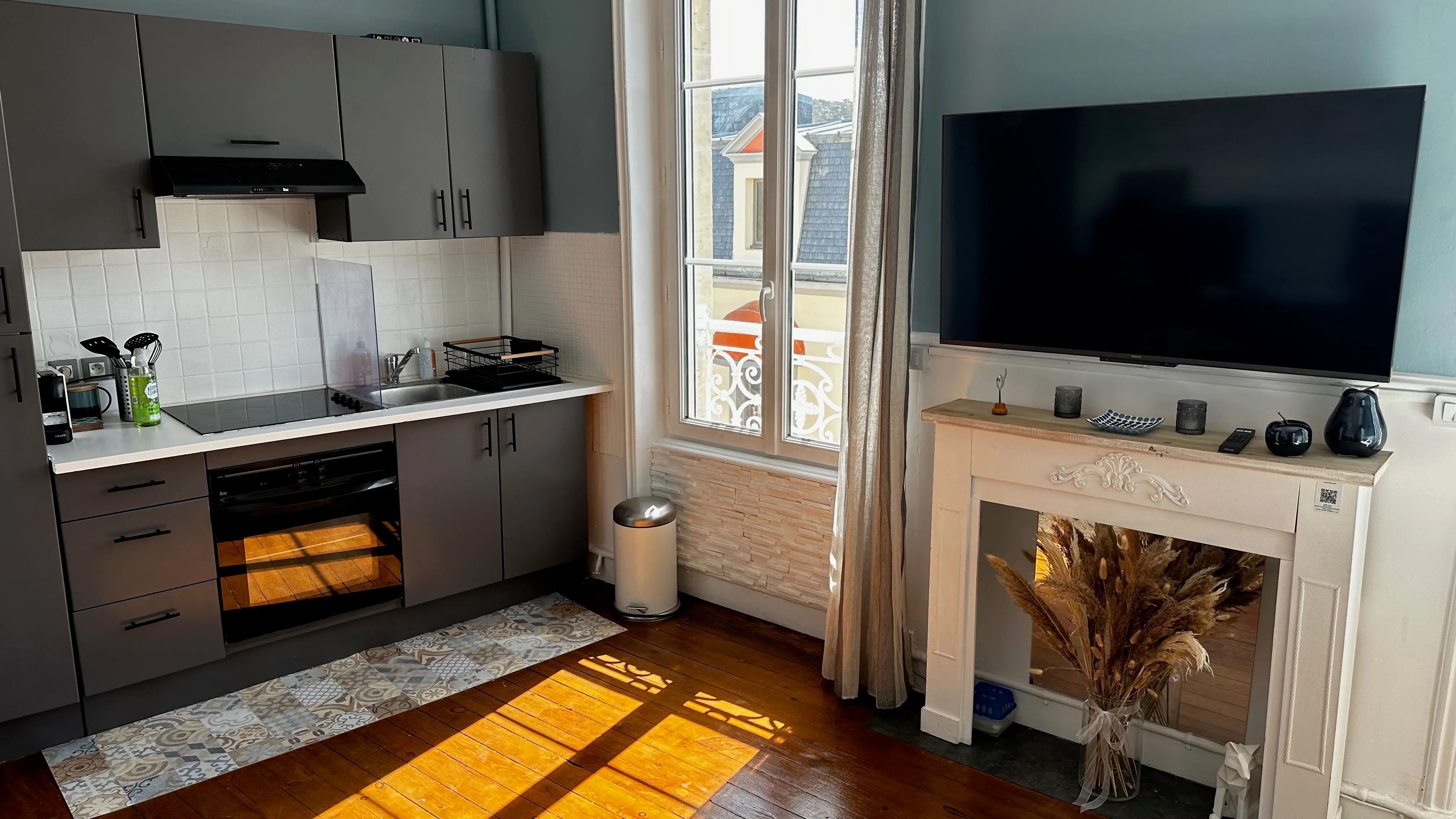 Fitted kitchen of the studio with period fireplace and wall-mounted TV