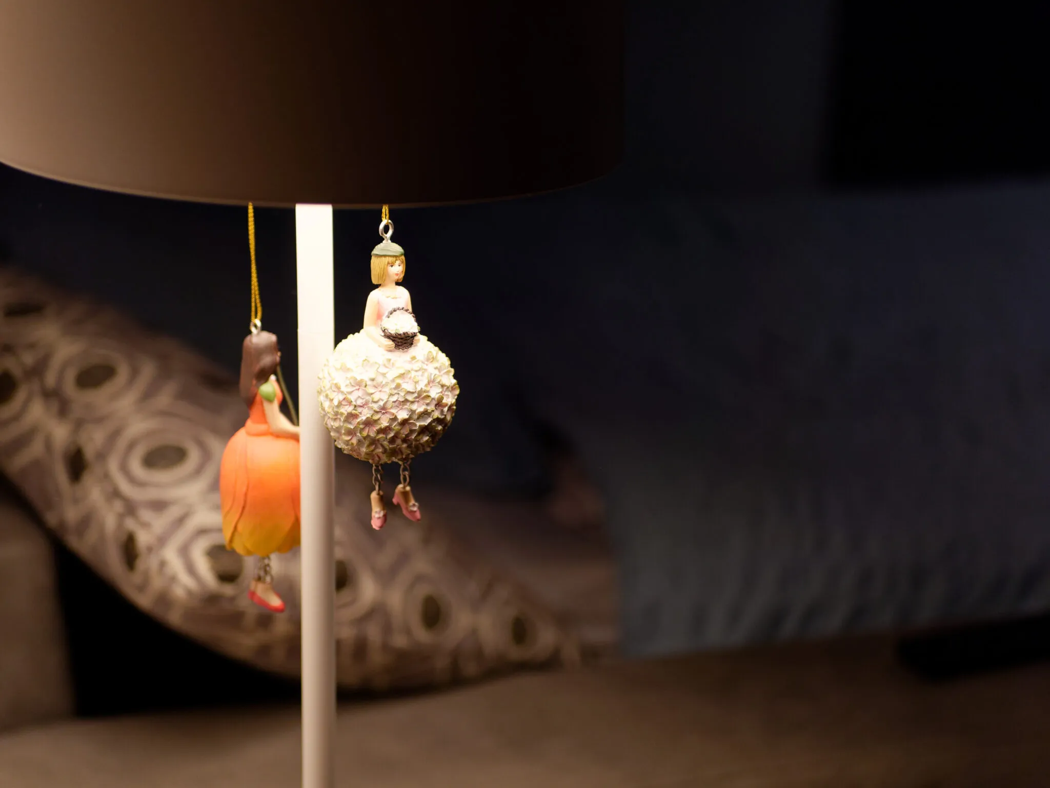 Decorative detail of the studio, figurines hanging from a lamp in soft light
