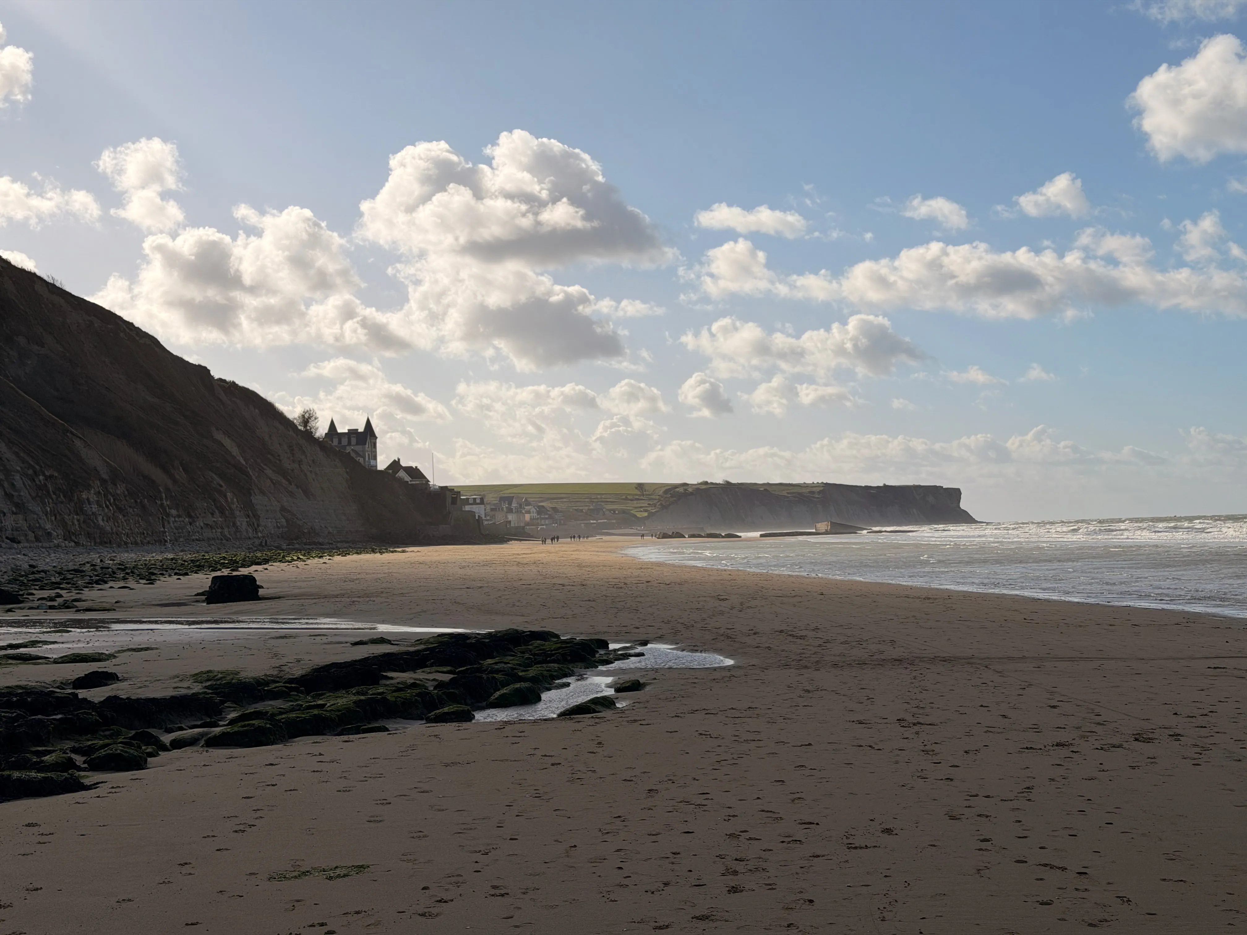 Beach and cliffs of Arromanches in golden late-day light
