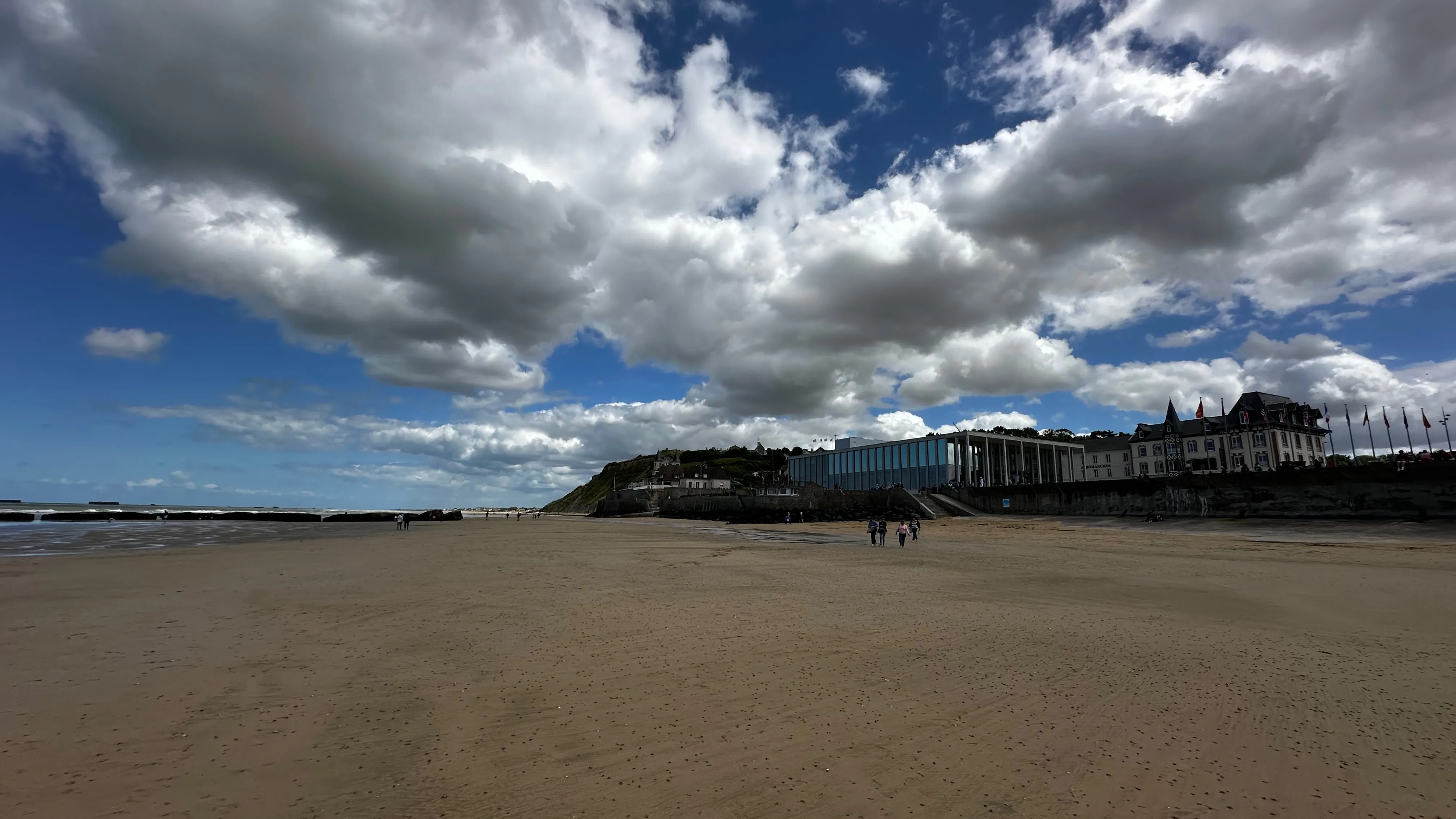 Arromanches beach with the D-Day Museum under a vast cloudy sky