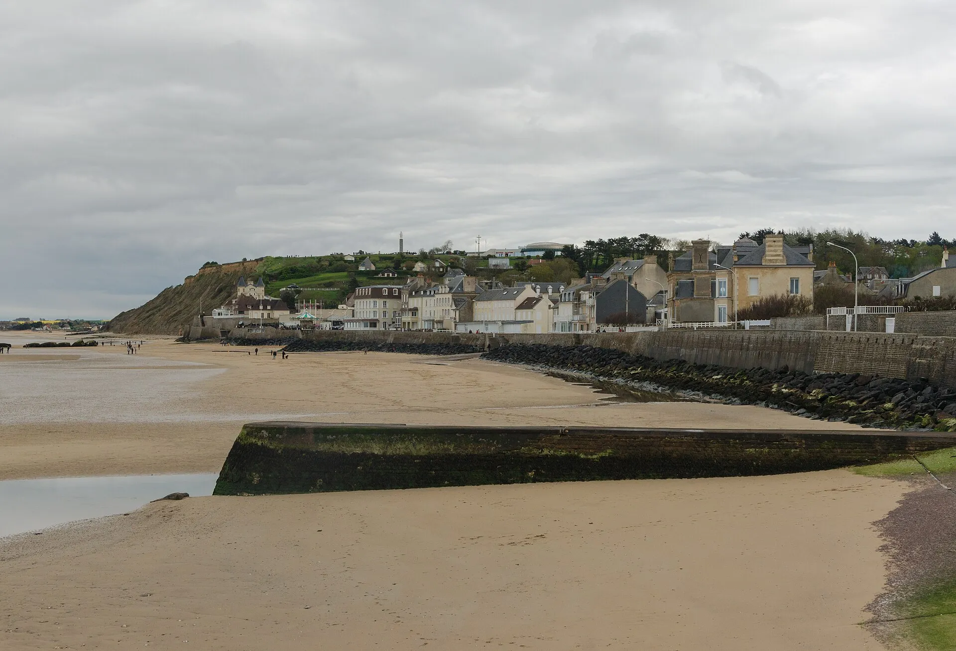 Vue d'ensemble du village d'Arromanches-les-Bains et de sa plage à marée basse